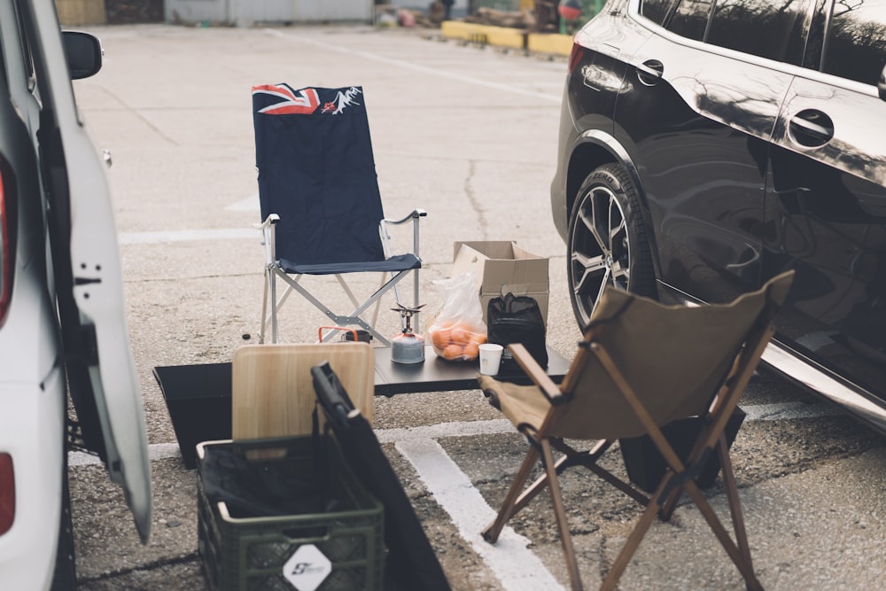 a car parked in a parking lot next to a camping table