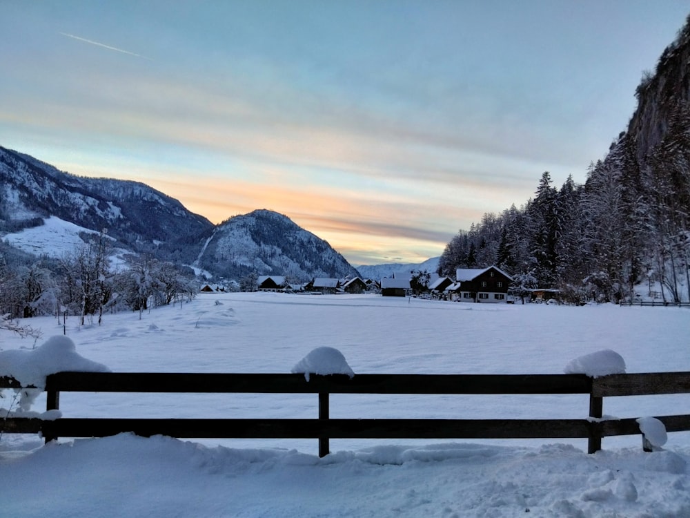 a snow covered field with mountains in the background