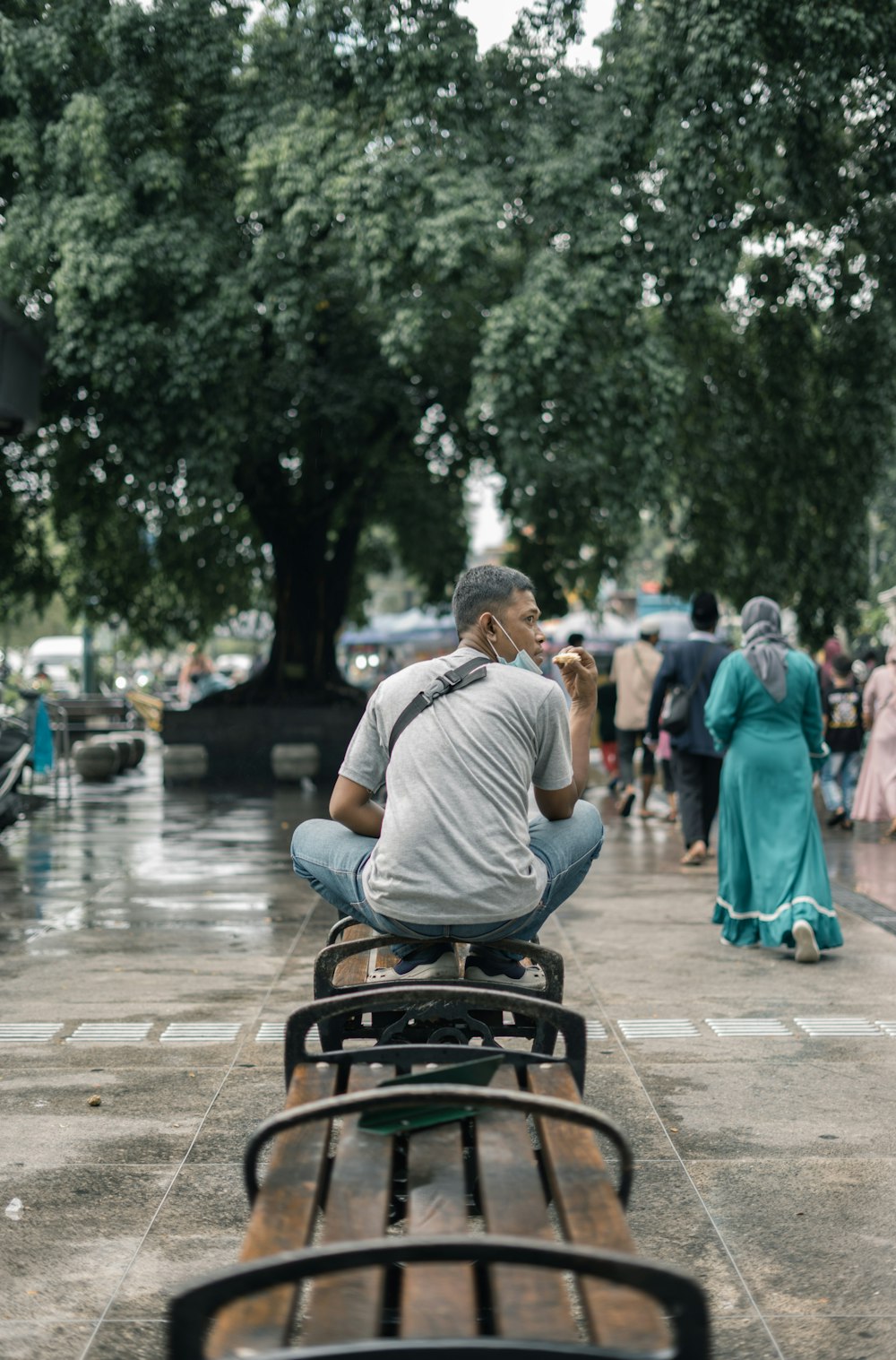 a man sitting on a bench in the rain