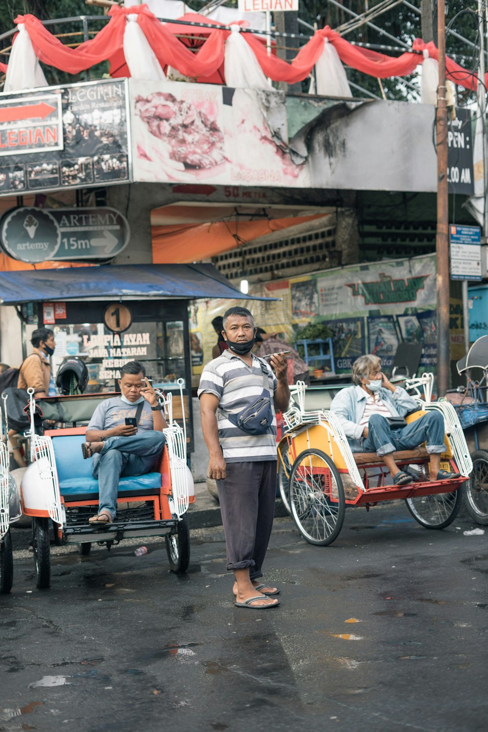 a man standing next to a group of people on a street