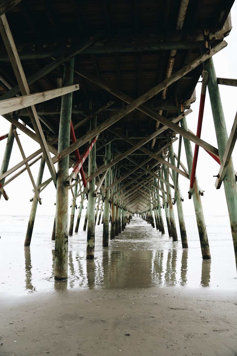 the underside of a pier with water underneath it
