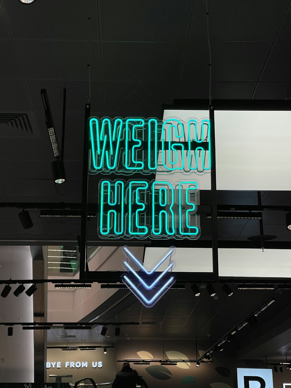 a neon sign hanging from the ceiling of a building