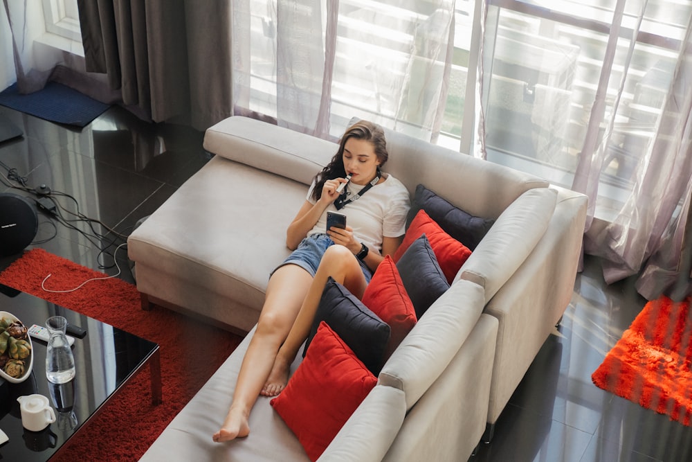 a woman sitting on a couch with a cell phone