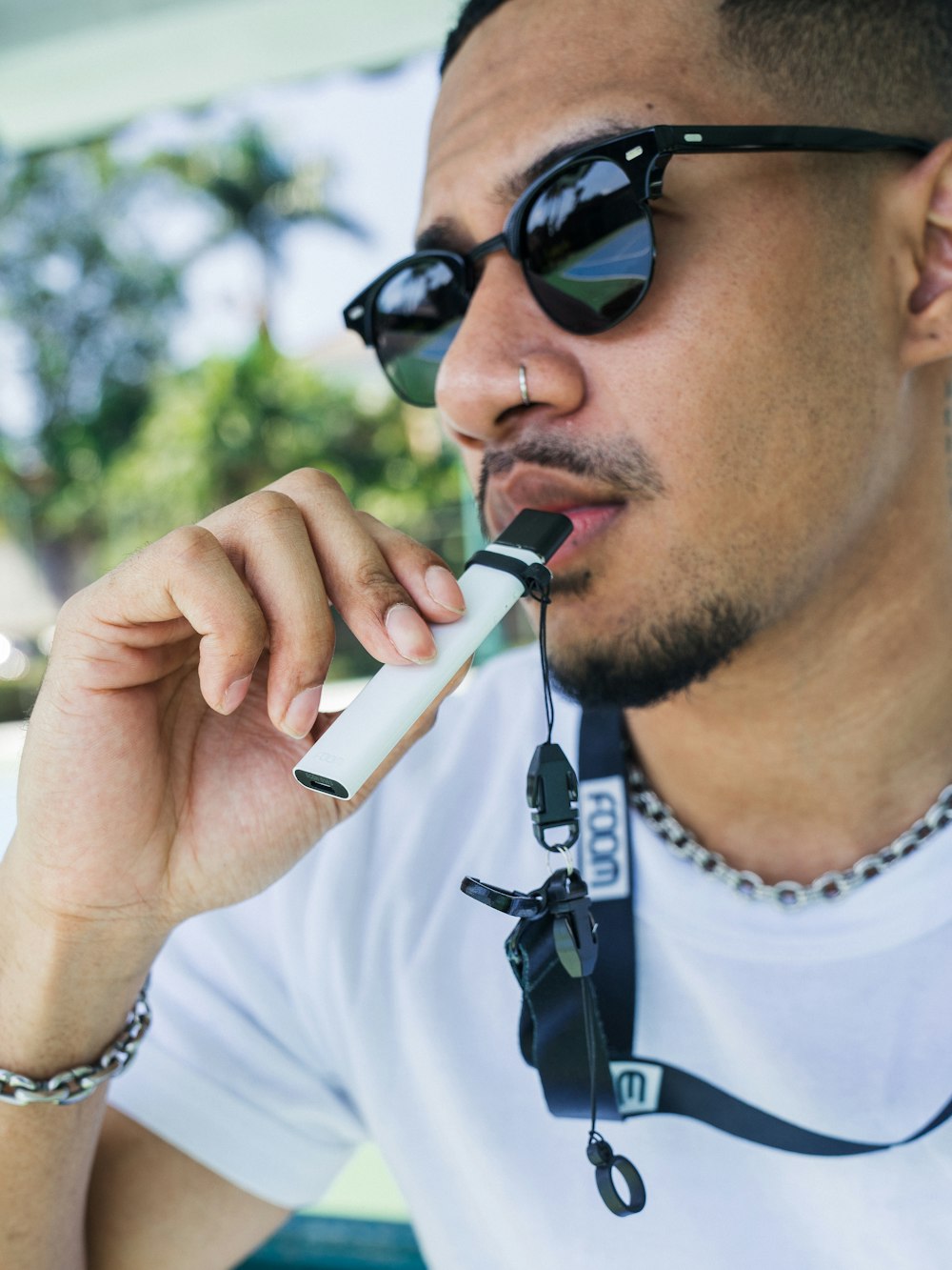 a man wearing sunglasses and holding a cell phone to his ear