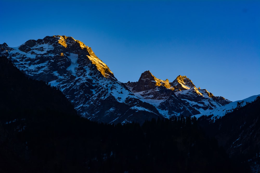 a snow covered mountain with a blue sky in the background