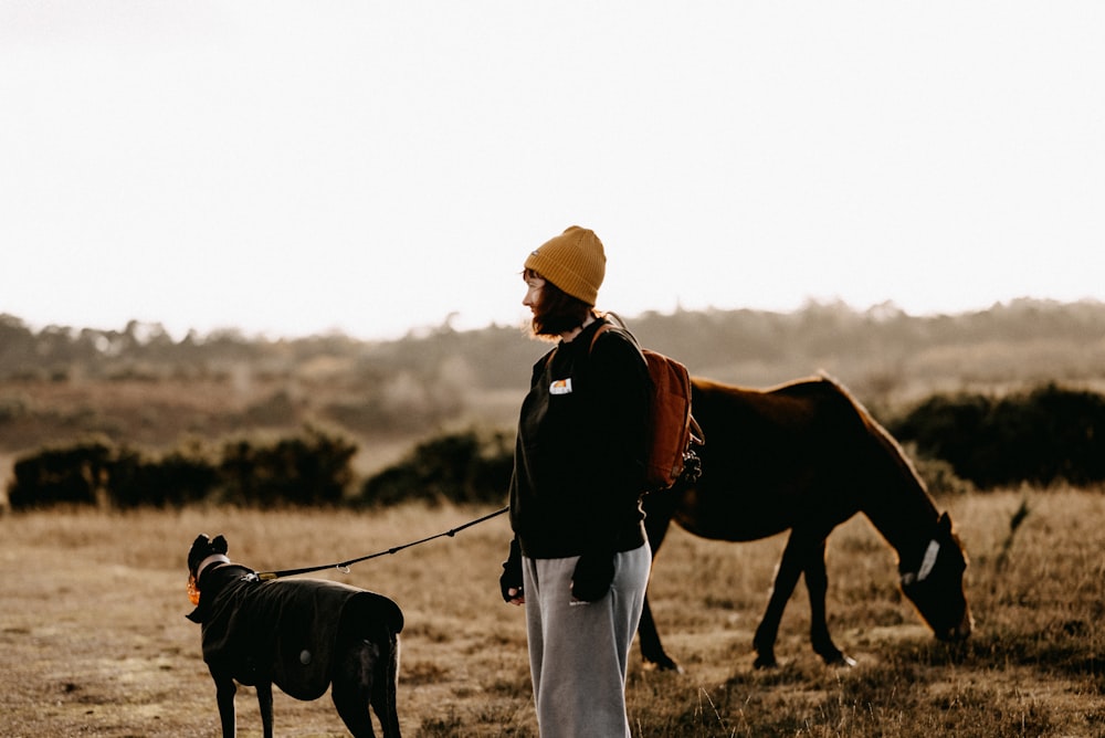 a man with a dog and a horse in a field