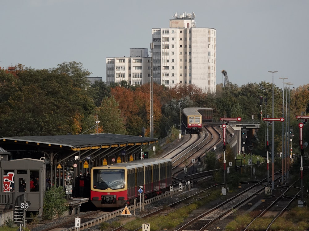 a train traveling down train tracks next to tall buildings