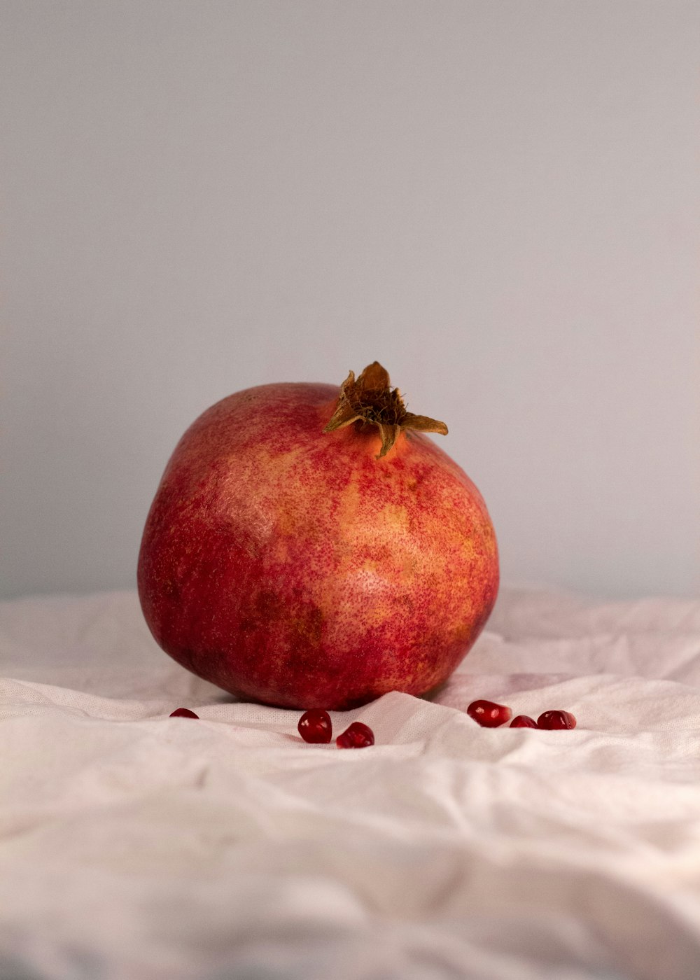 a pomegranate sitting on top of a white sheet