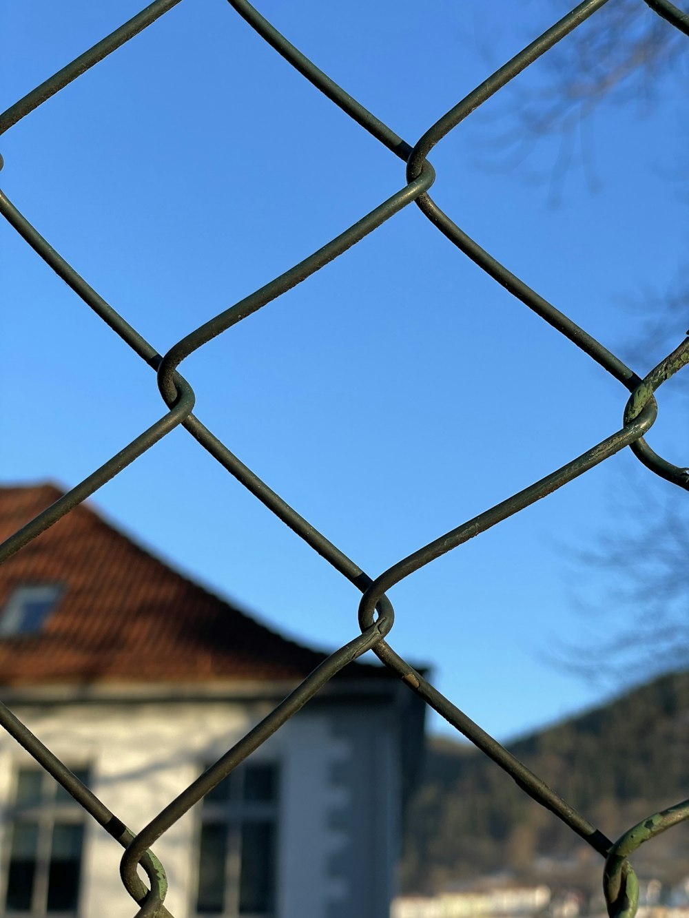 a chain link fence with a house in the background