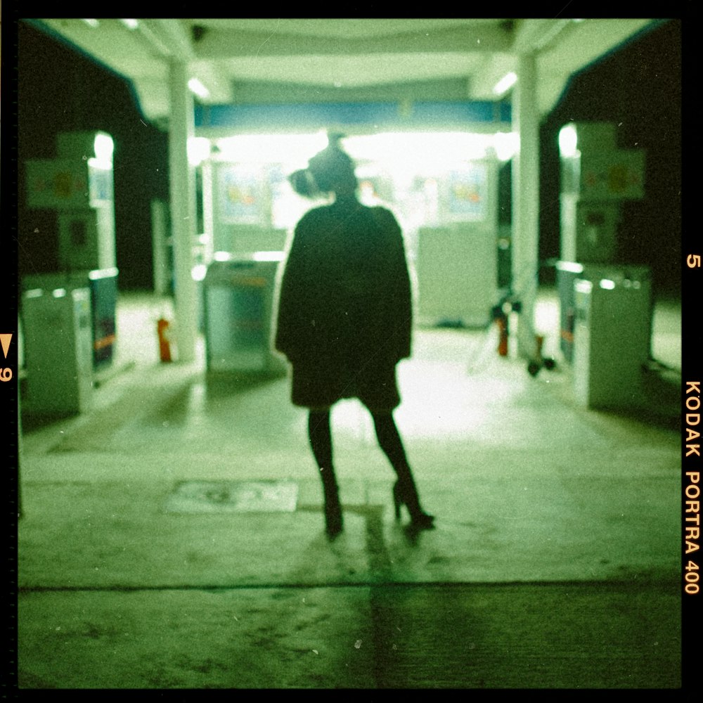 a woman walking down a street at night