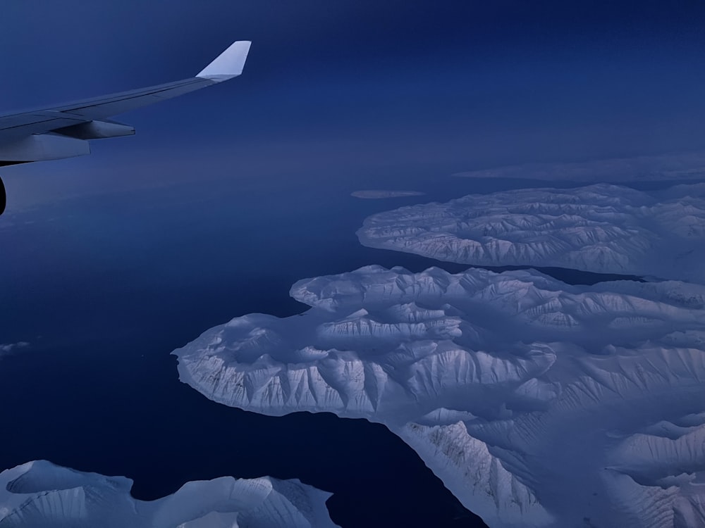 an airplane wing flying over a large body of water