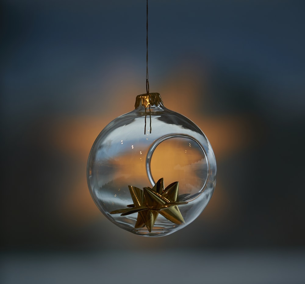 a glass ornament with a gold star hanging from it