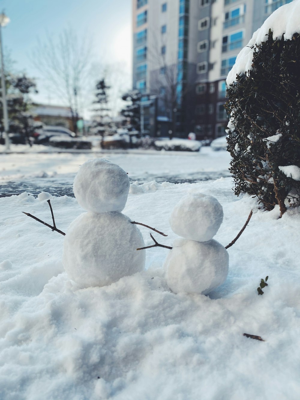 un couple de bonhommes de neige qui sont dans la neige