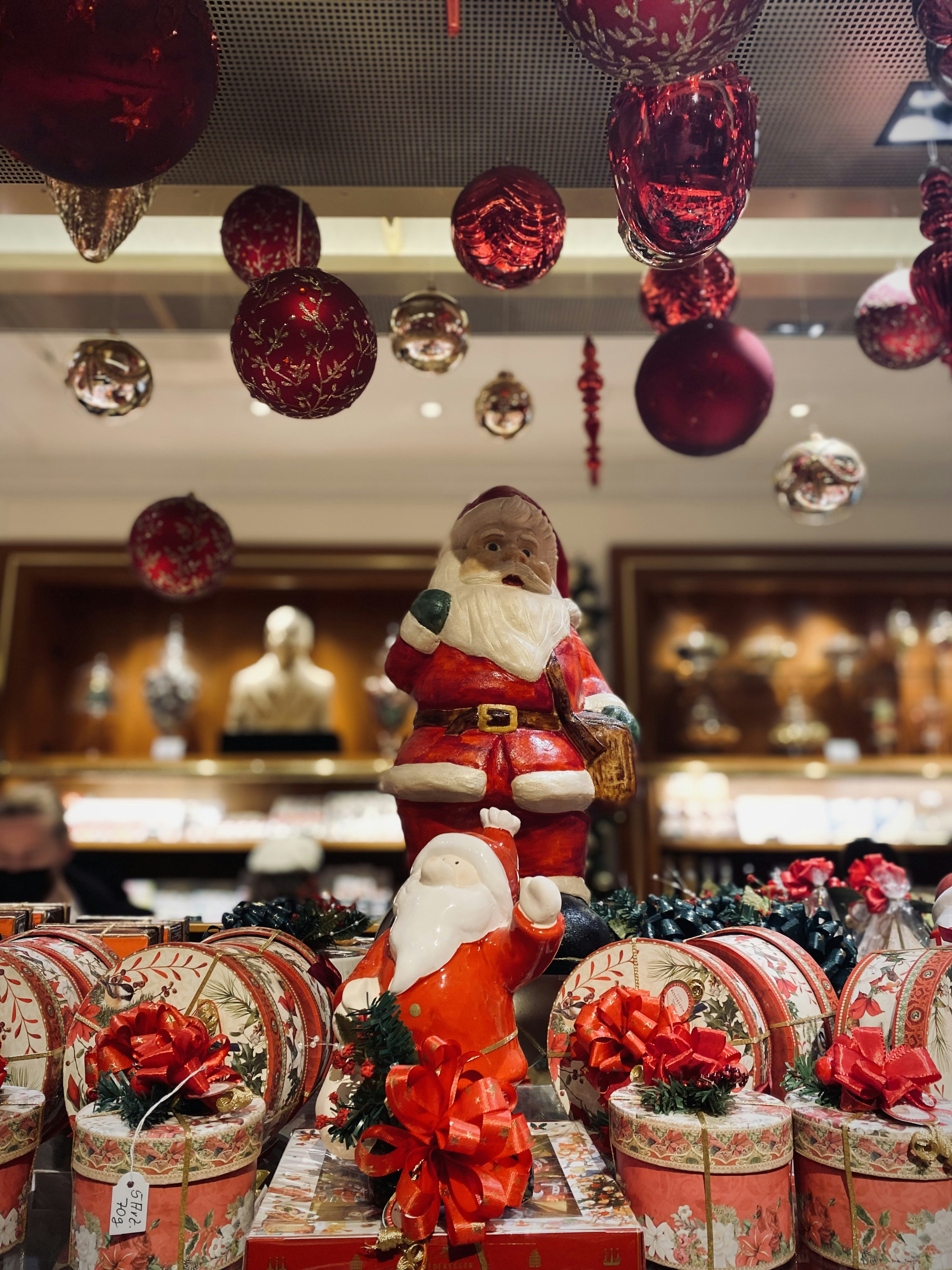 Una figura de Santa Claus sentada encima de una pila de regalos