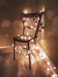 An assembled wooden chair in a warmly lit living room corner.