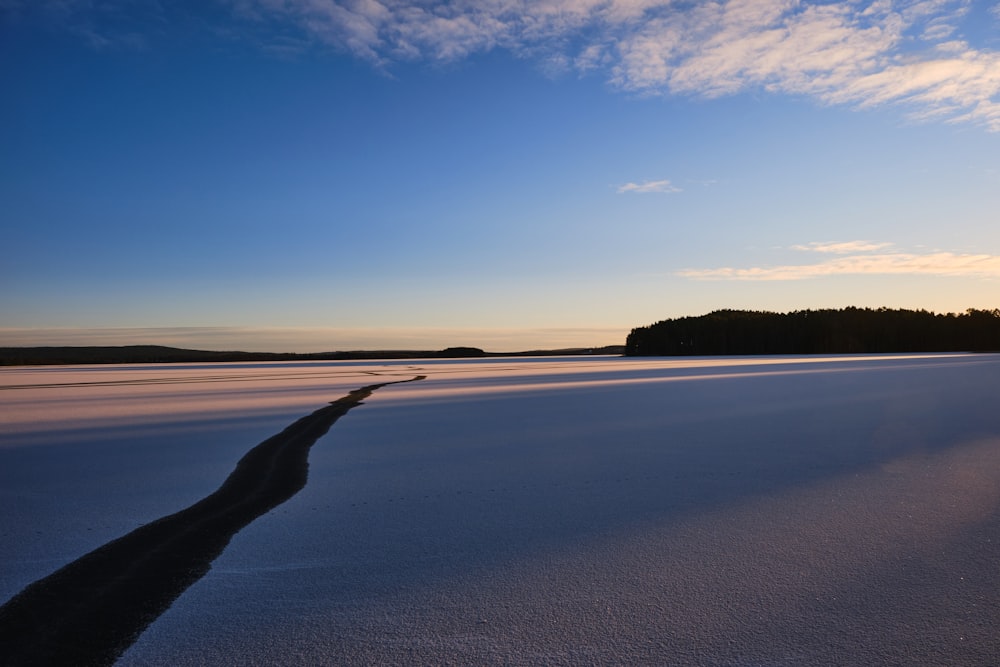 a large body of water sitting under a blue sky