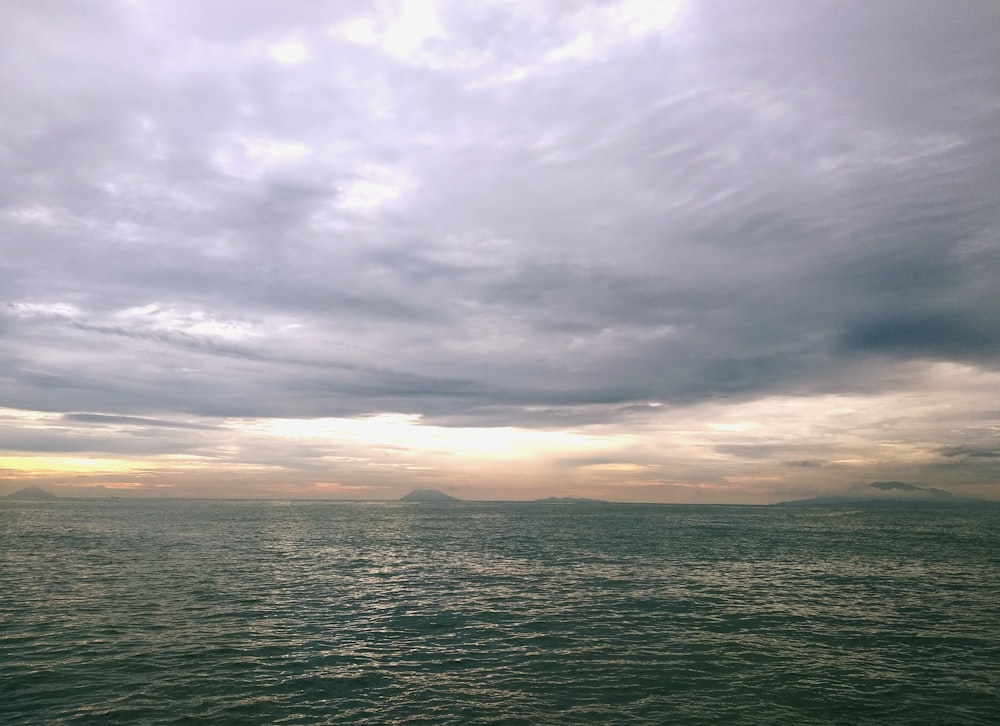 a large body of water under a cloudy sky