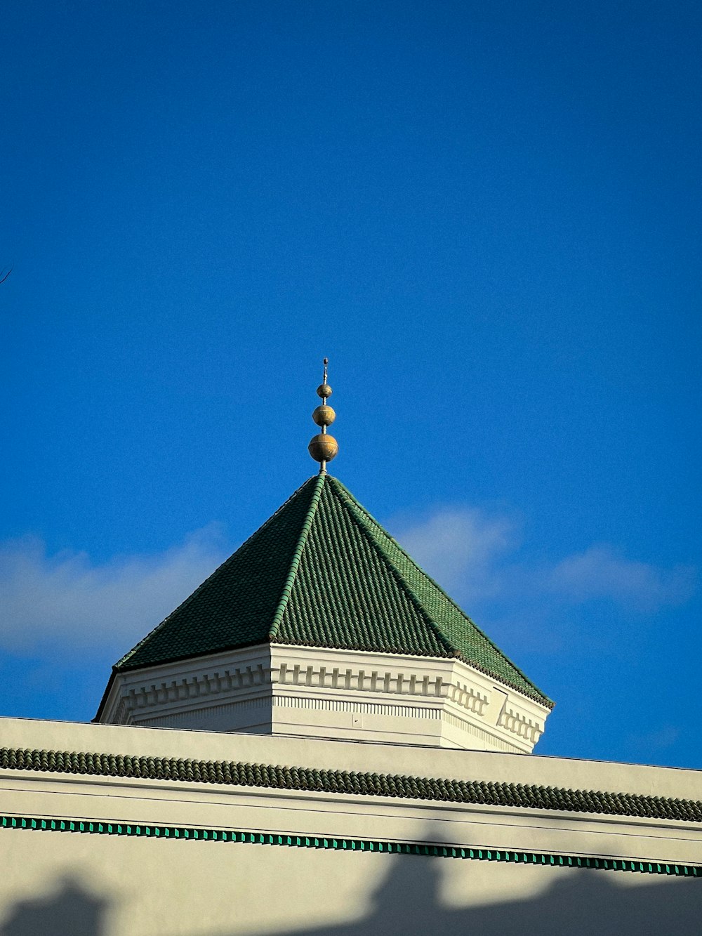 a large white building with a green roof