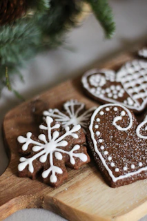 An assortment of beautifully decorated dog cookies arranged on a rustic wooden board.