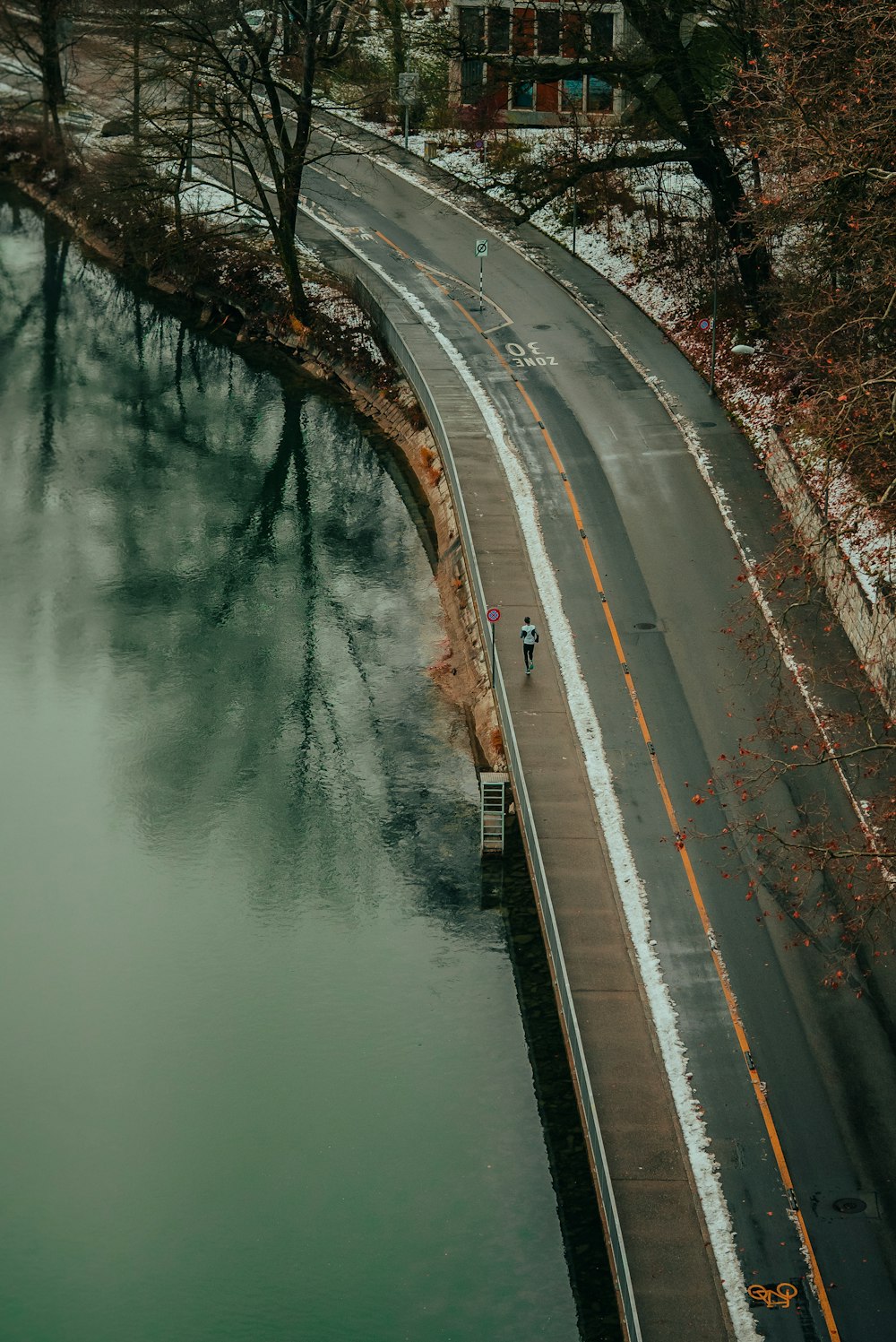 a person riding a bike down a road next to a body of water