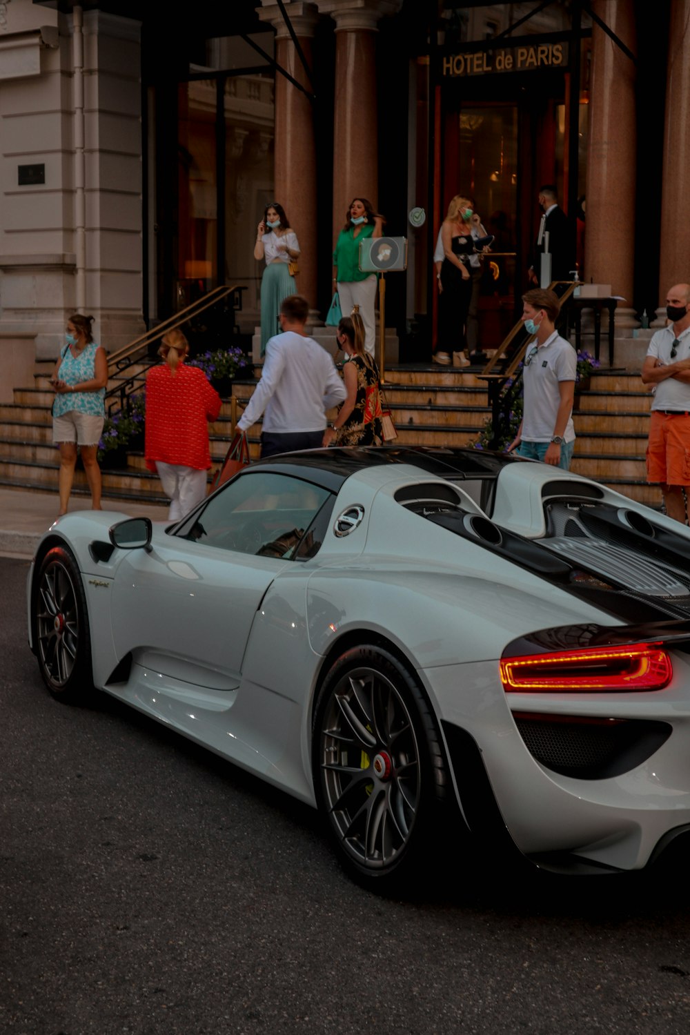 a white sports car parked in front of a hotel