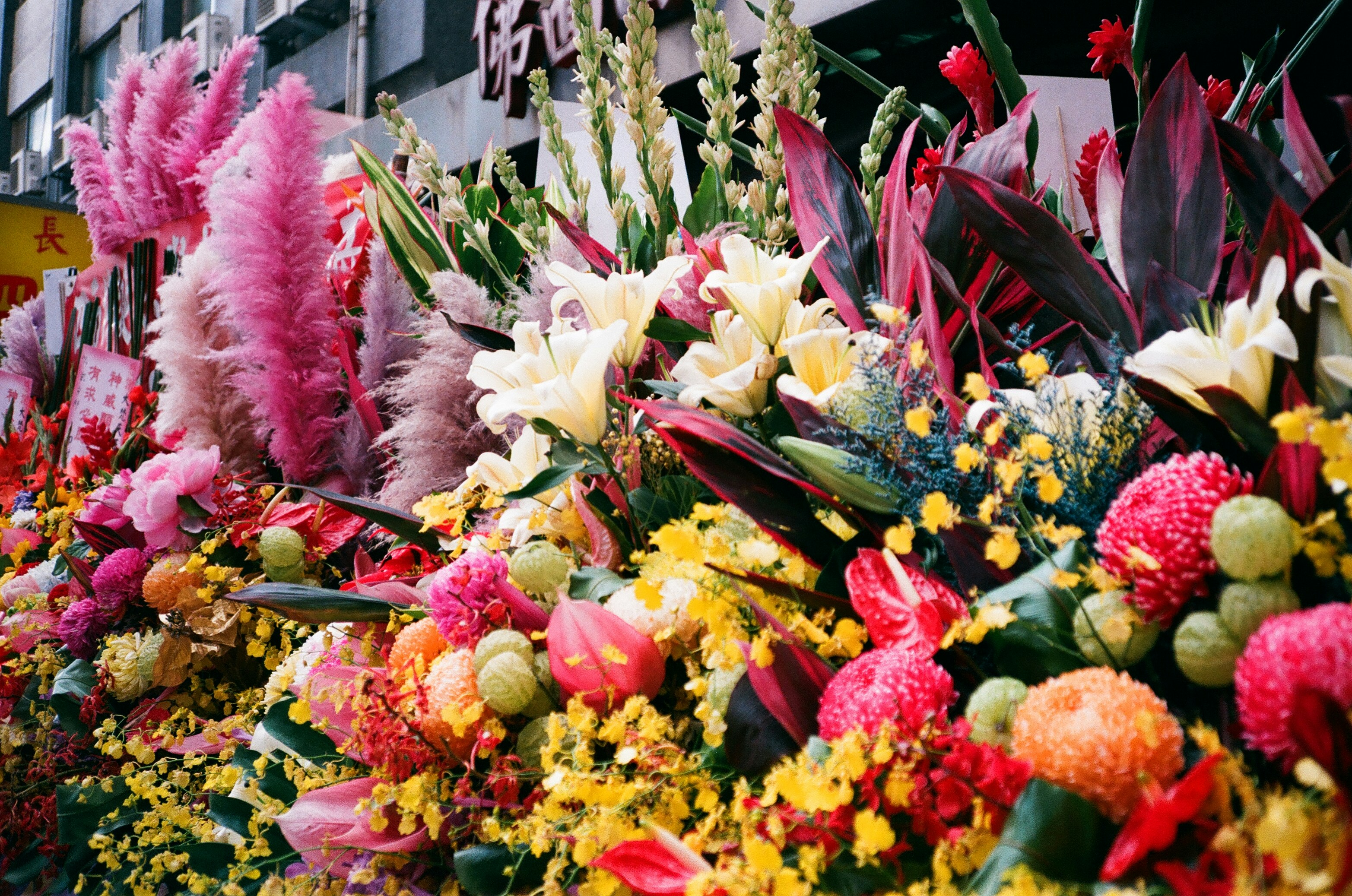 a bunch of flowers that are sitting in the grass, The most famous Erawan Temple in Taipei, Taiwan.