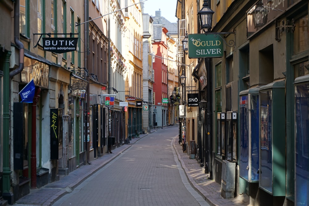 a narrow city street lined with buildings and shops