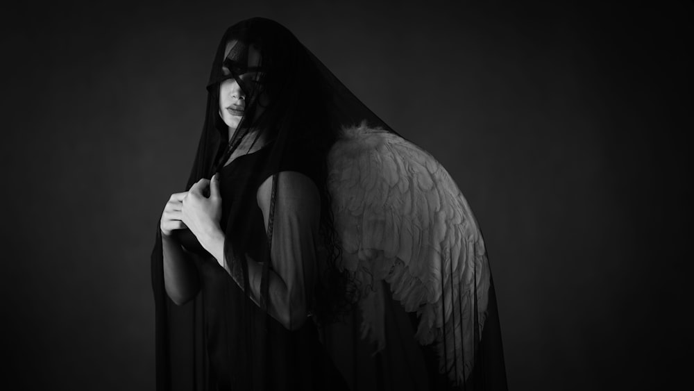a woman in a black dress with an angel wings