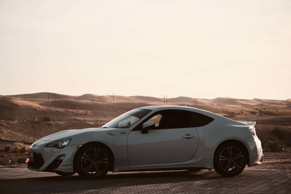 a white sports car parked in the desert