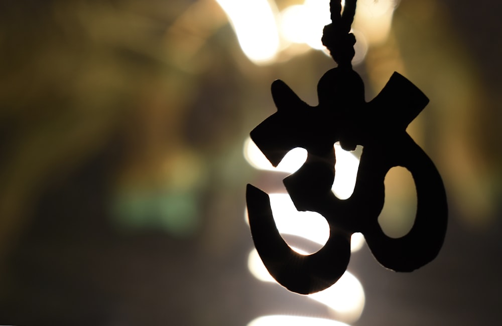 a close up of a cross hanging from a string