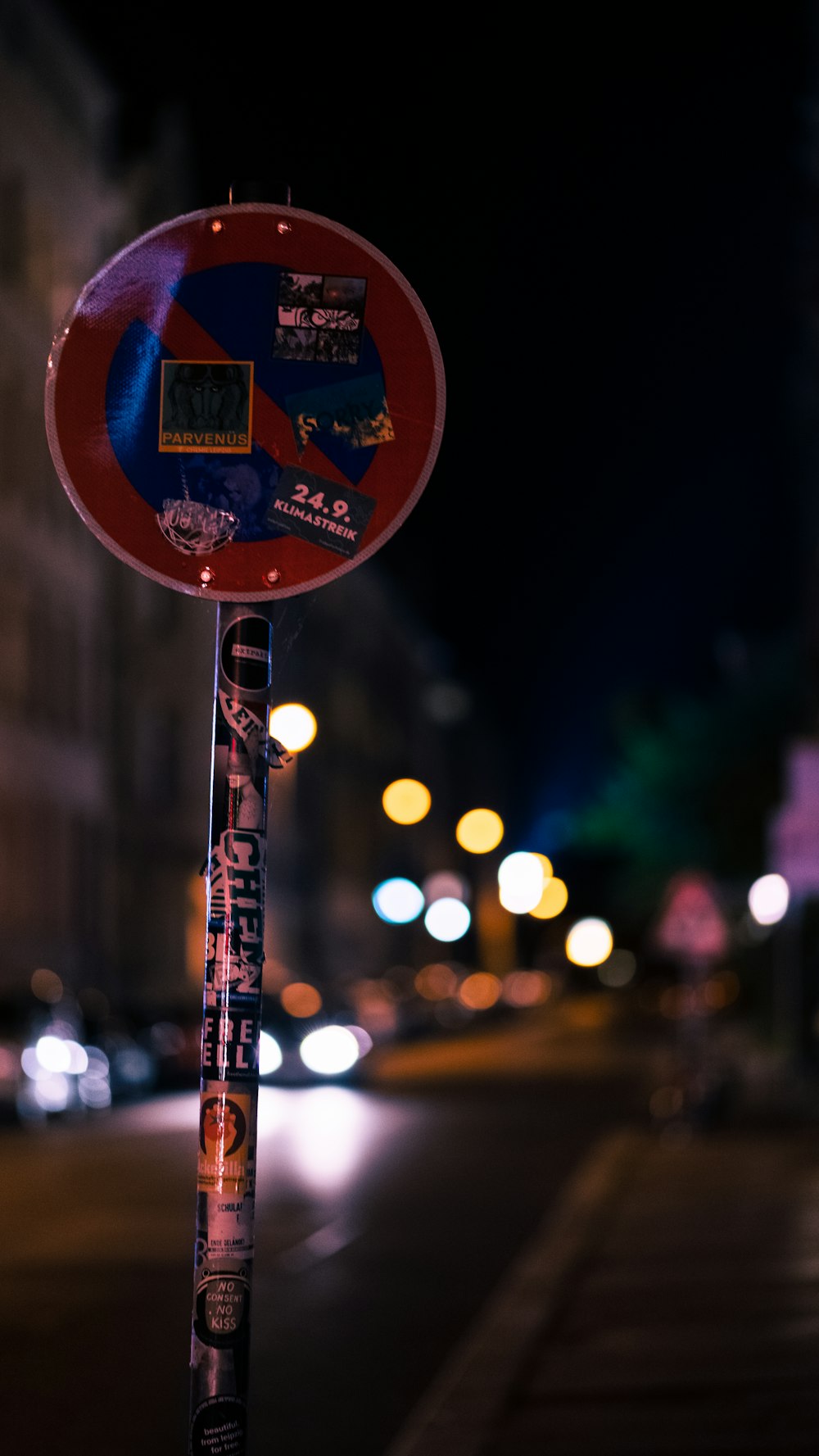 a red and blue street sign sitting on the side of a road