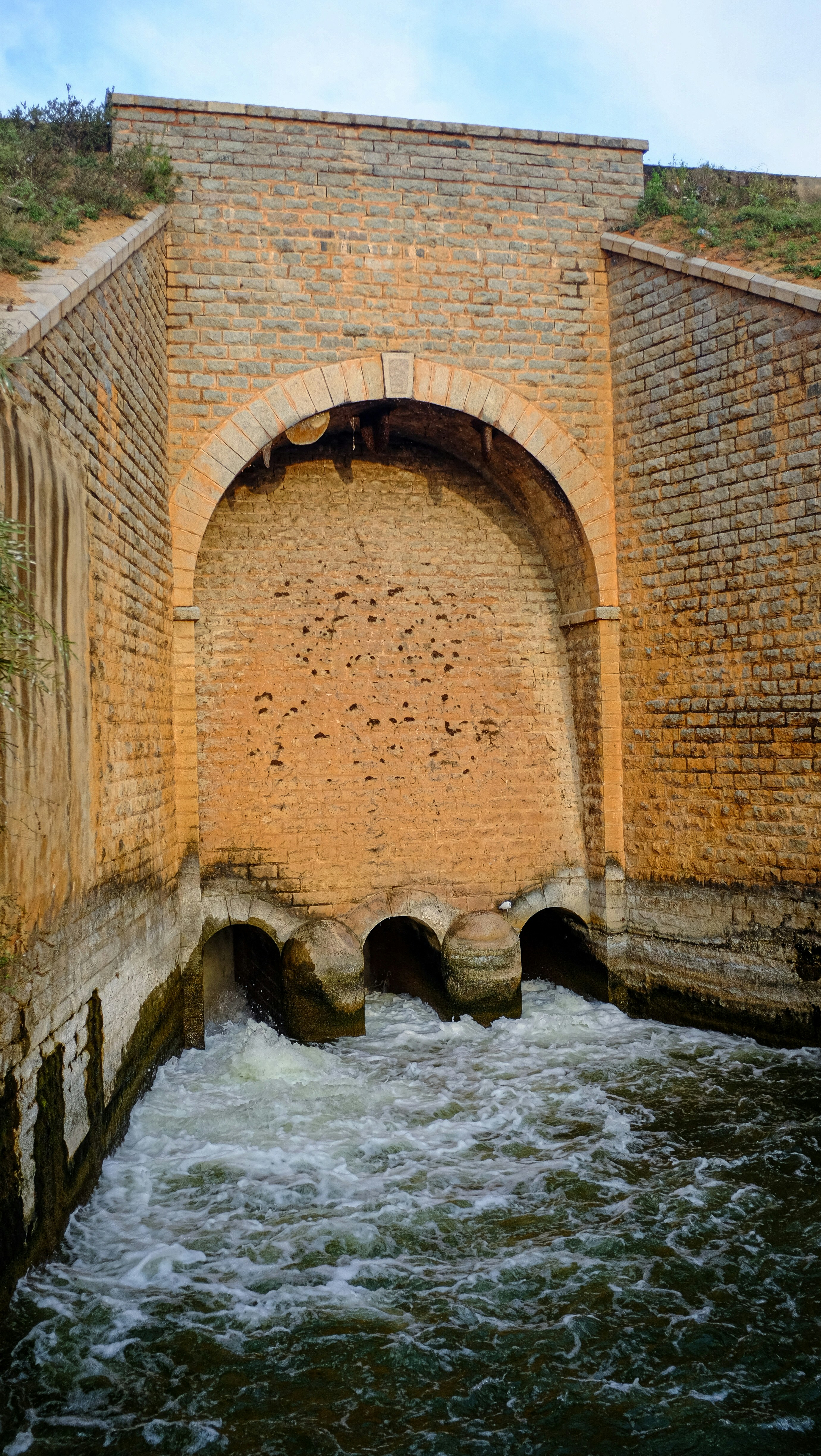 A large brick structure with a river running underneath it