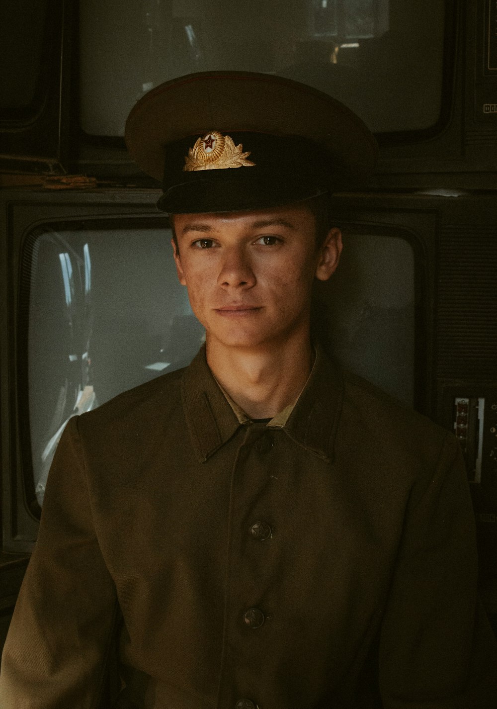 a man in a uniform standing in front of a tv