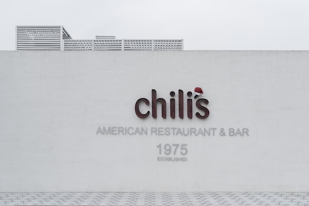 Un bâtiment blanc avec une enseigne qui dit Chilli’s American Restaurant and Bar