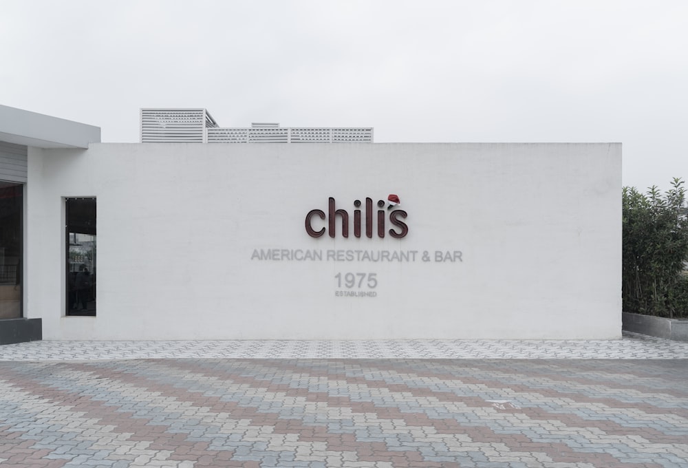 a white building with a sign that says chilis american restaurant & bar