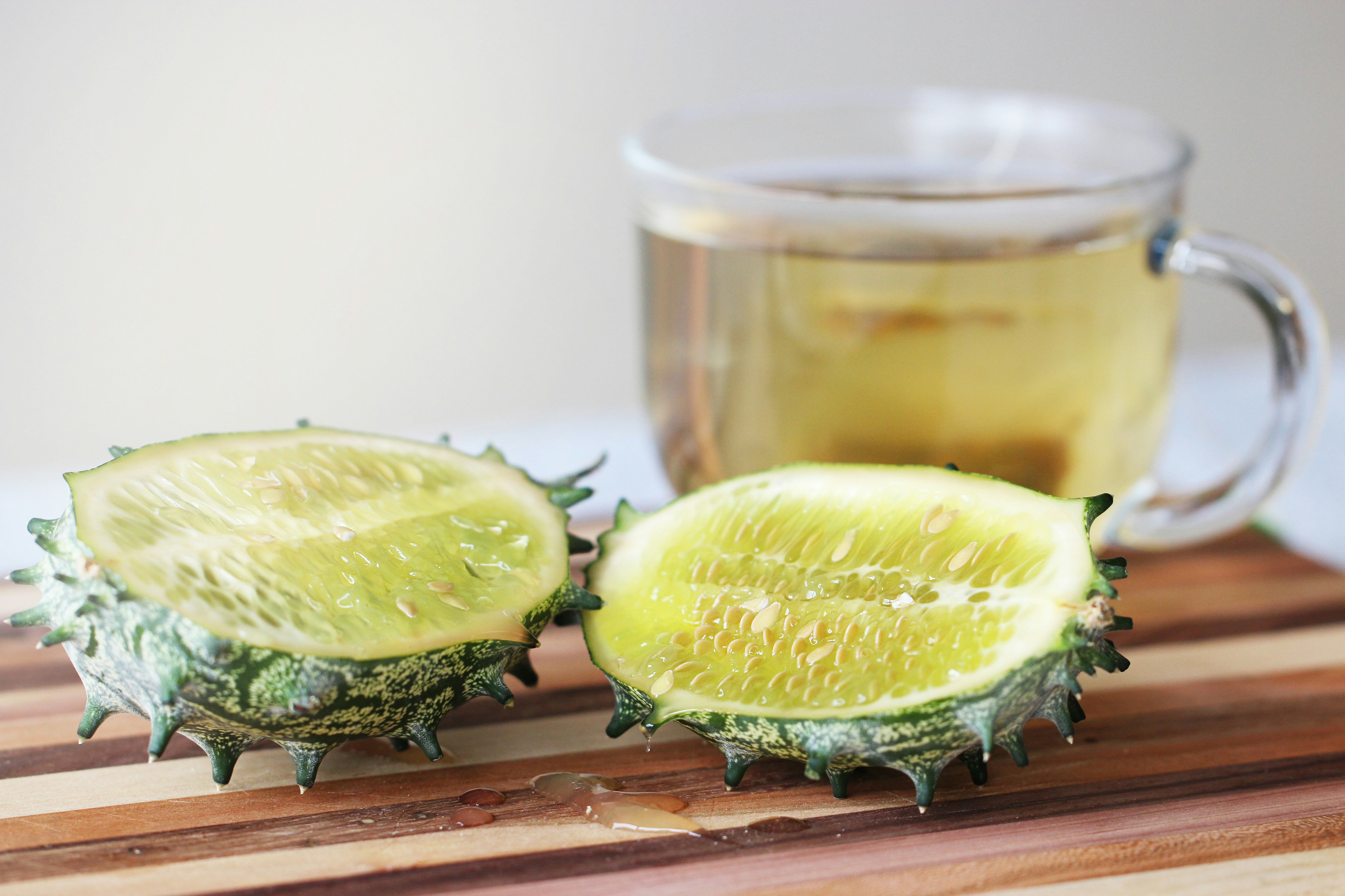 a couple of pieces of fruit sitting on top of a wooden cutting board, 