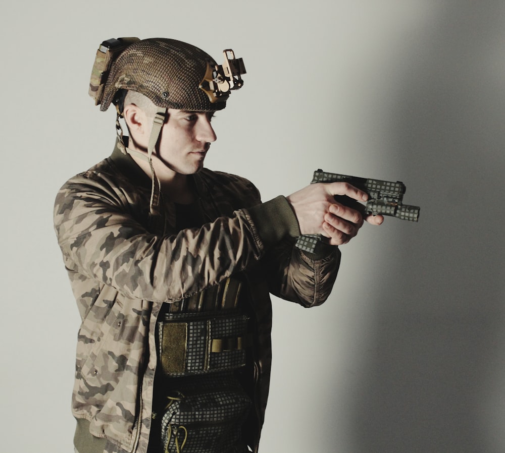 Un hombre con uniforme militar sosteniendo un arma