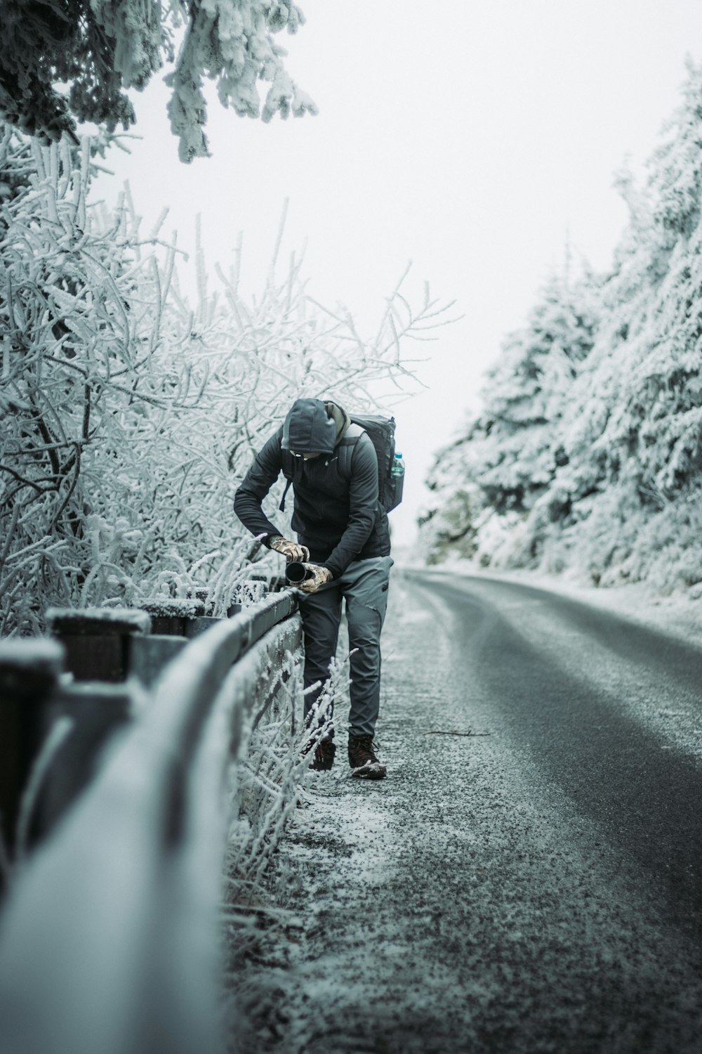 a man walking down a road in the snow