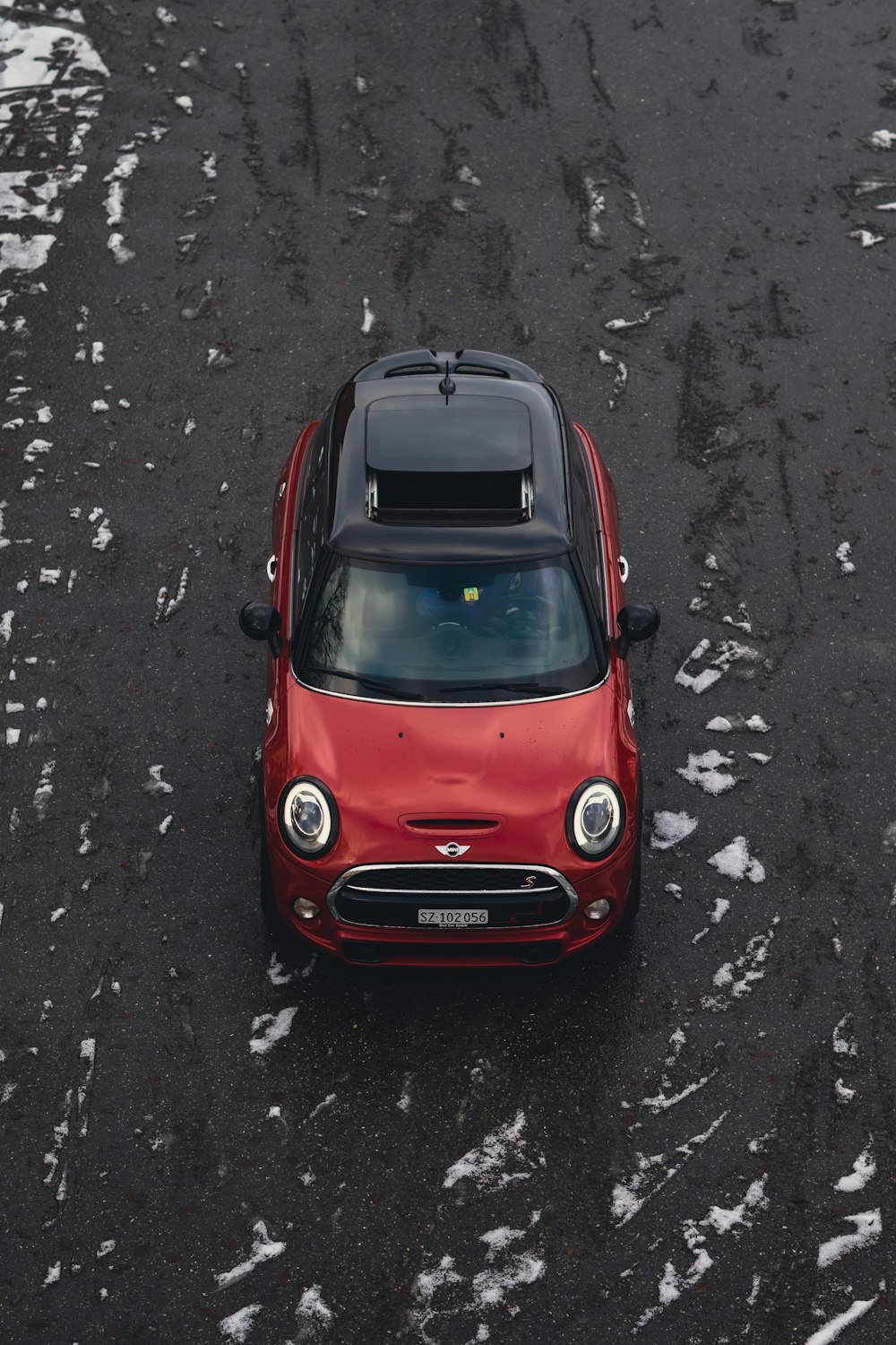 a small red car parked in a parking lot