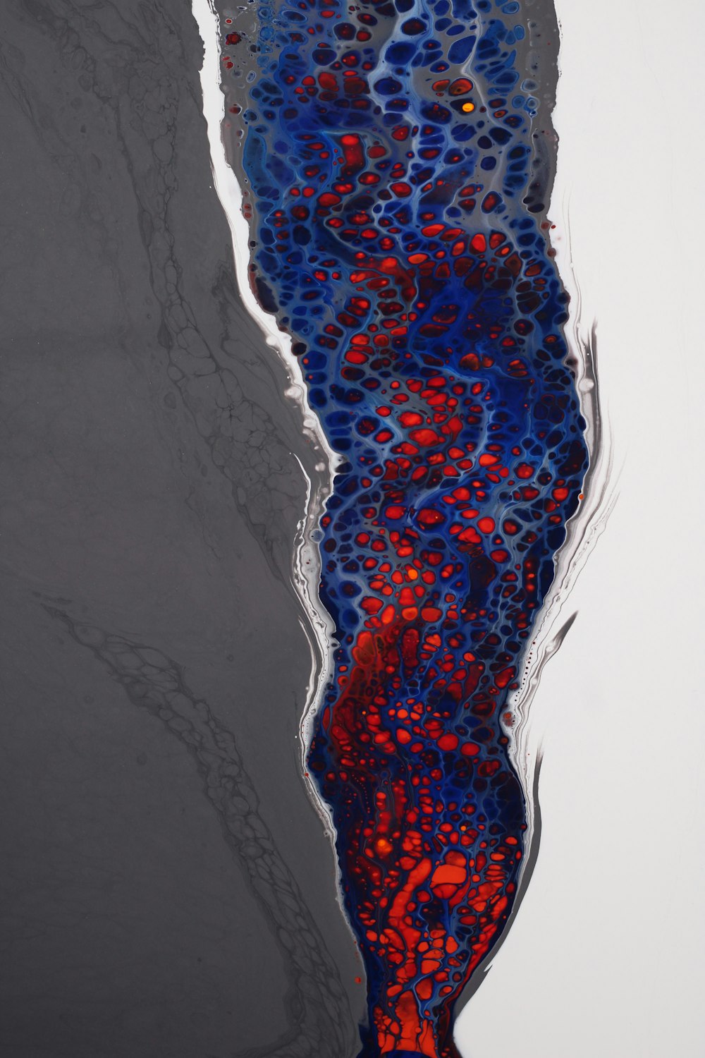 a red and blue substance floating on top of a body of water