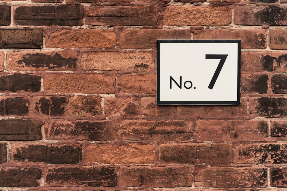 Un letrero en una pared de ladrillos que dice No 7