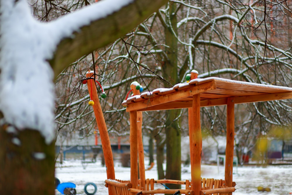 a wooden swing set in a snowy park