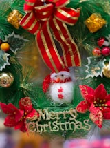 a christmas wreath with a snowman and poinsettis