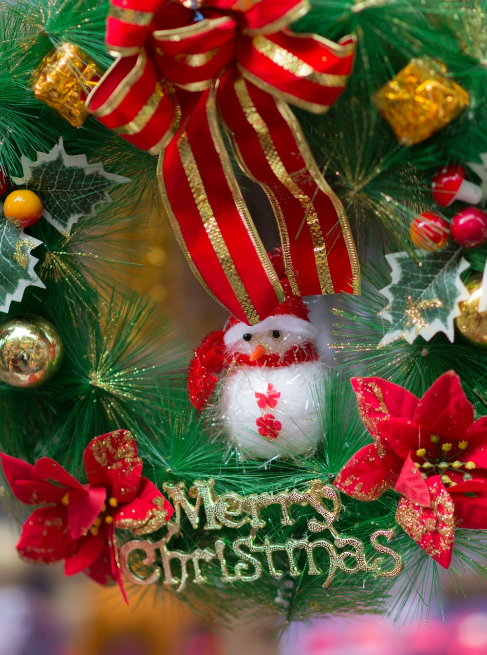 a christmas wreath with a snowman and poinsettis