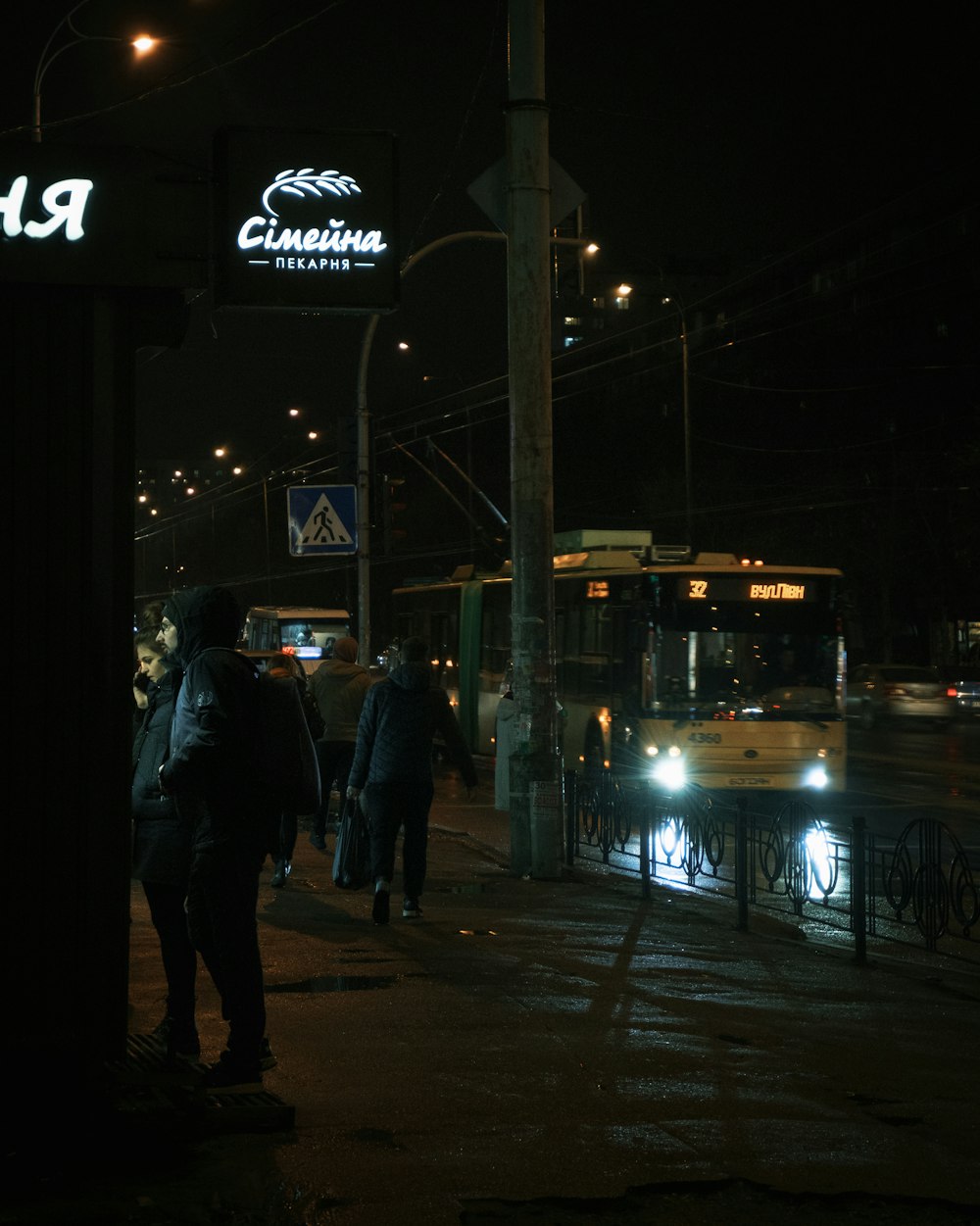 a group of people walking down a street at night