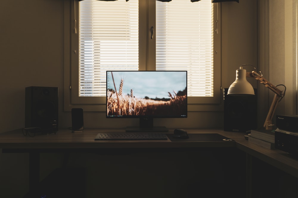 un computer desktop seduto sopra una scrivania di legno