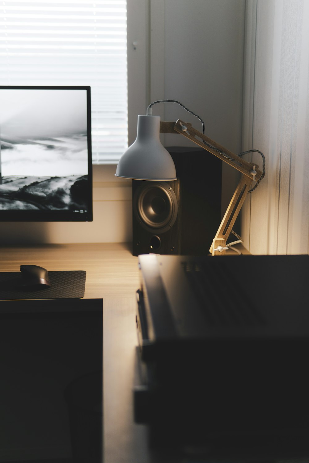 a desk with a computer monitor and speakers