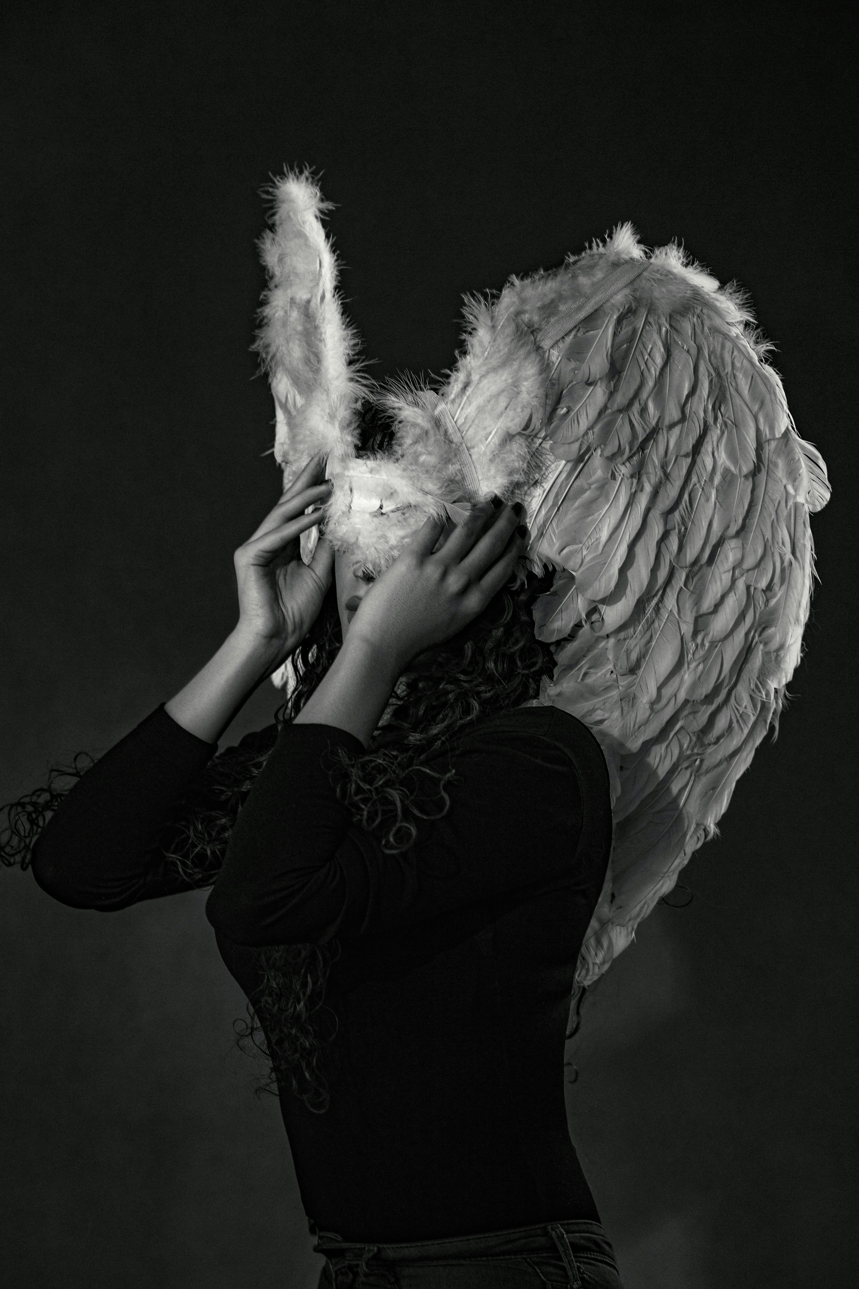 A woman with angel wings covering her face photo Free Art Image on