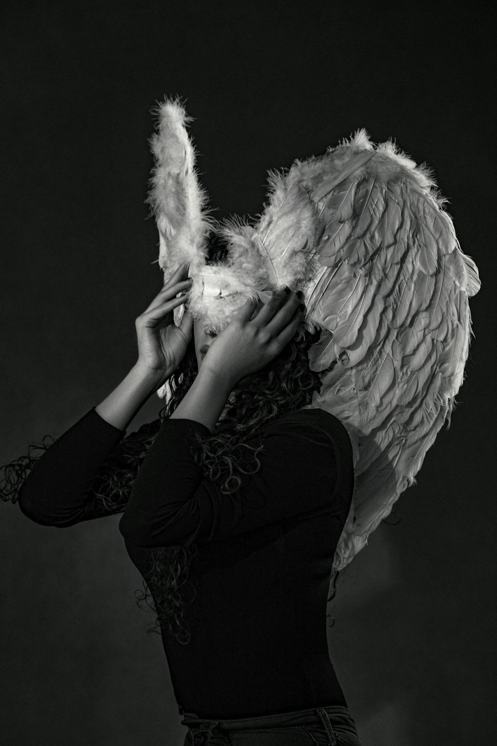 a woman with angel wings covering her face