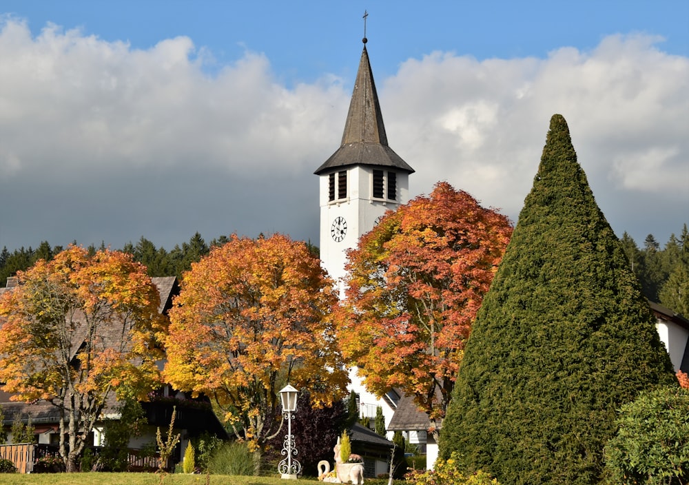 a church with a clock tower surrounded by trees
